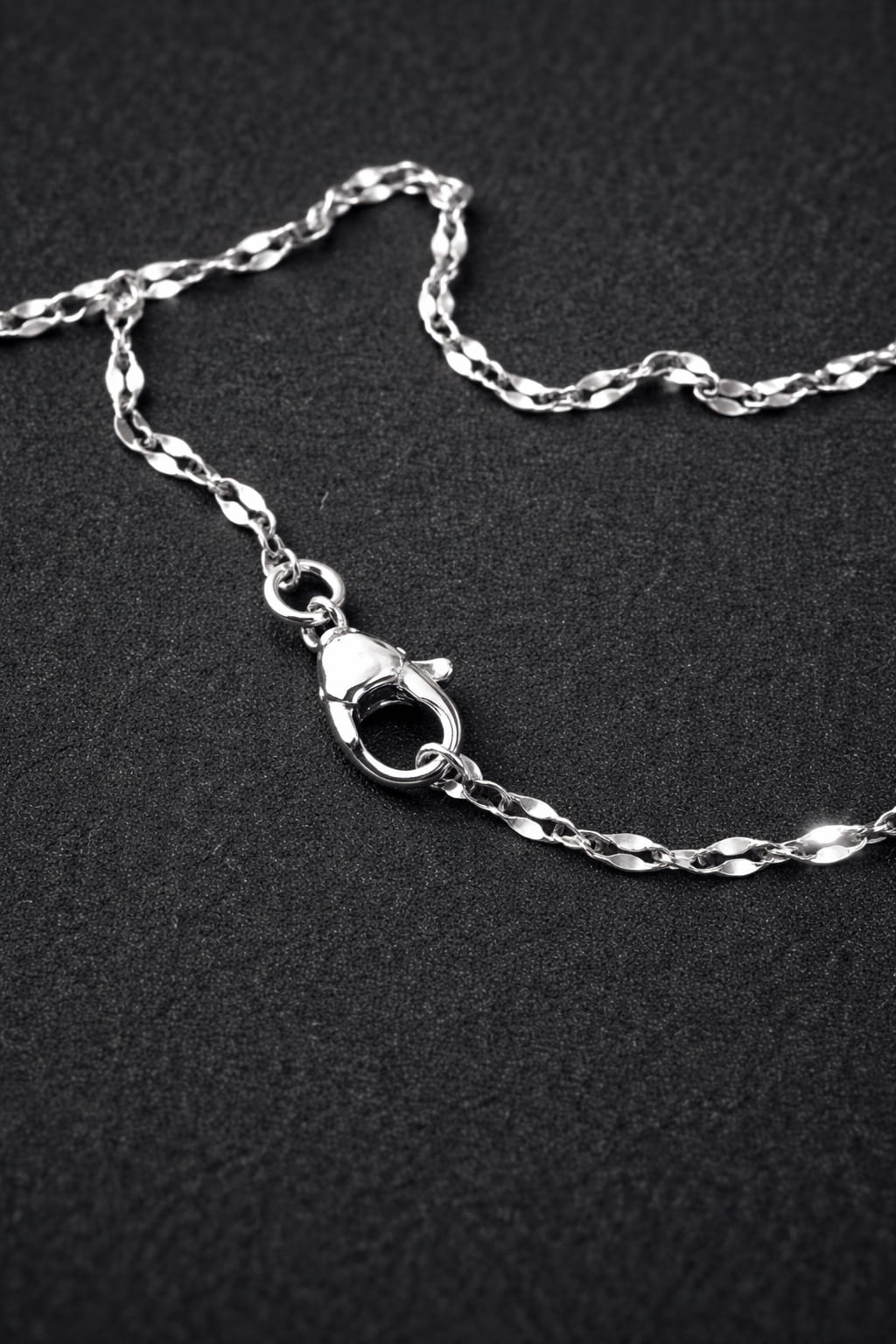 Detaljbild av elegant kedja i rostfritt stål med karbinlås