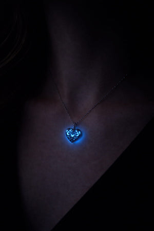 Modell som bär handgjort självlysande hjärthalsband i rostfritt stål
