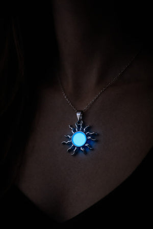 Person som bär silverfärgat solhalsband som lyser blått i mörker