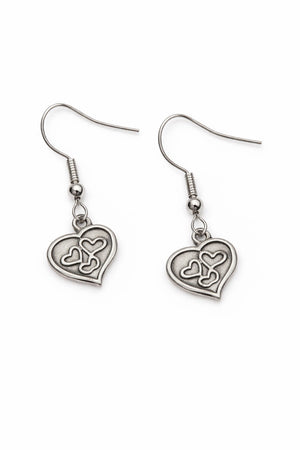 Små självlysande hjärtörhängen på vit bakgrund i dagsljus