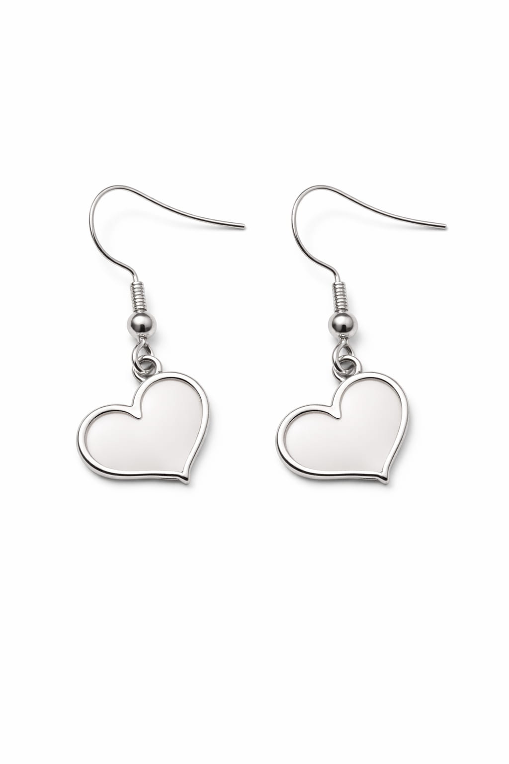 Hjärtörhängen i rostfritt stål på vit bakgrund i dagsljus