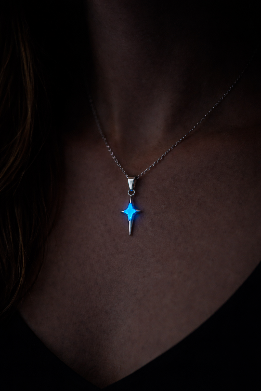 Person som bär nordstjärna halsband med blått sken i mörker