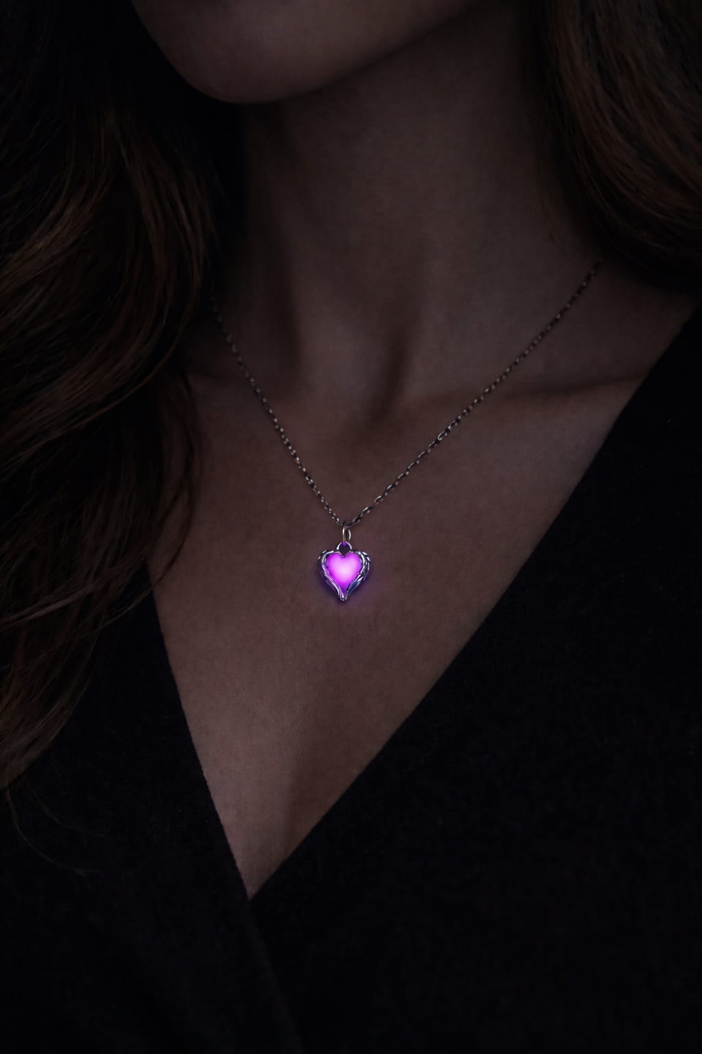 Självlysande hjärthalsband med rosa/lila sken buren på person i mörker