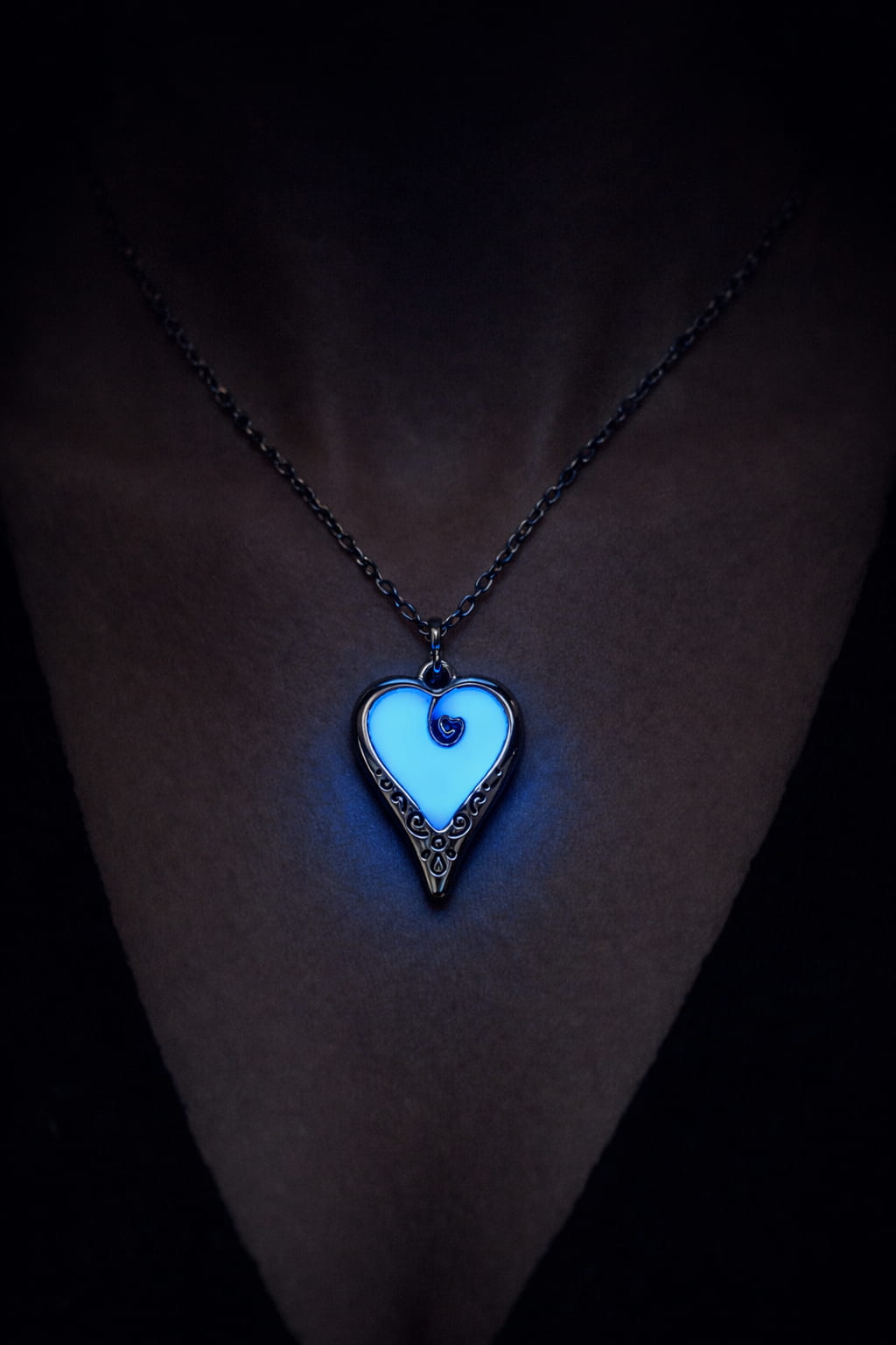 Självlysande hjärthalsband med mörkblå ton och blått sken buren på person