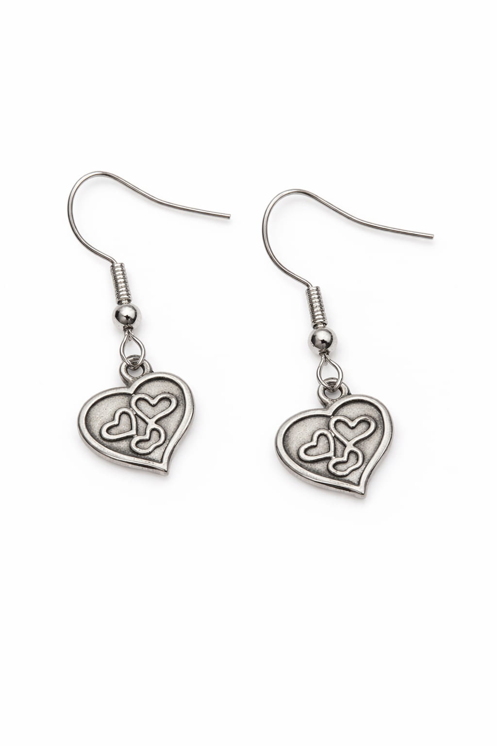 Små självlysande hjärtörhängen på vit bakgrund i dagsljus